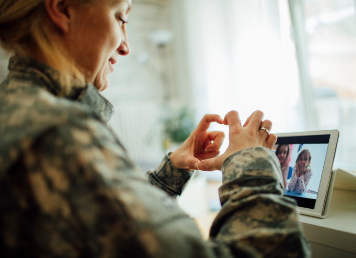 Military Mom talking with her children over digital tablet. Using modern technologies and communication to talk to her kids. Children making heart shape with fingers and mother touching screen. Shot with Canon EOS 5Ds